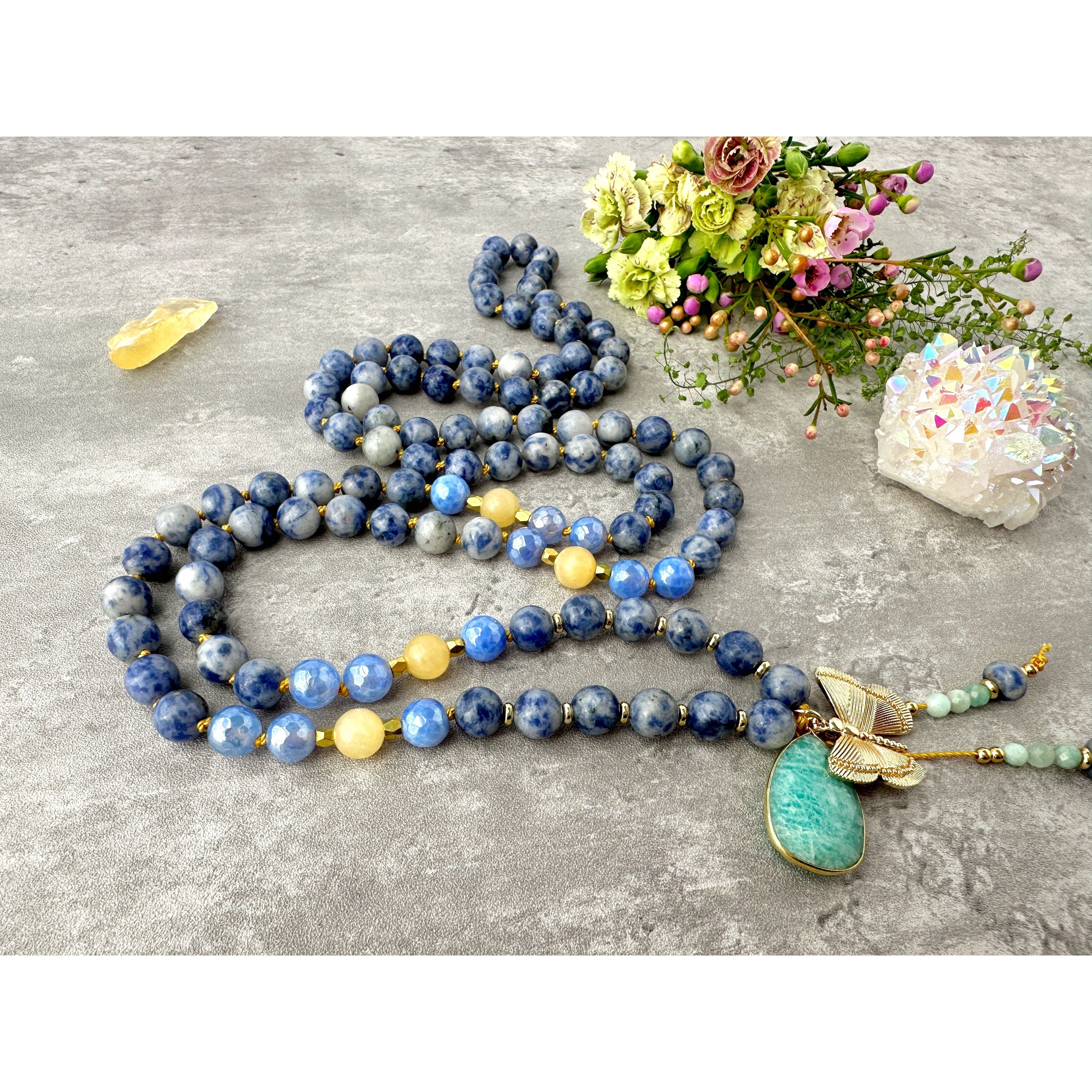 mala beads necklace with blue yellow gemstones. spotted jasper yellow jade blue fire agate meditation necklace knotted with nylon cord between each bead. amazonite guru crystal and butterfly charm